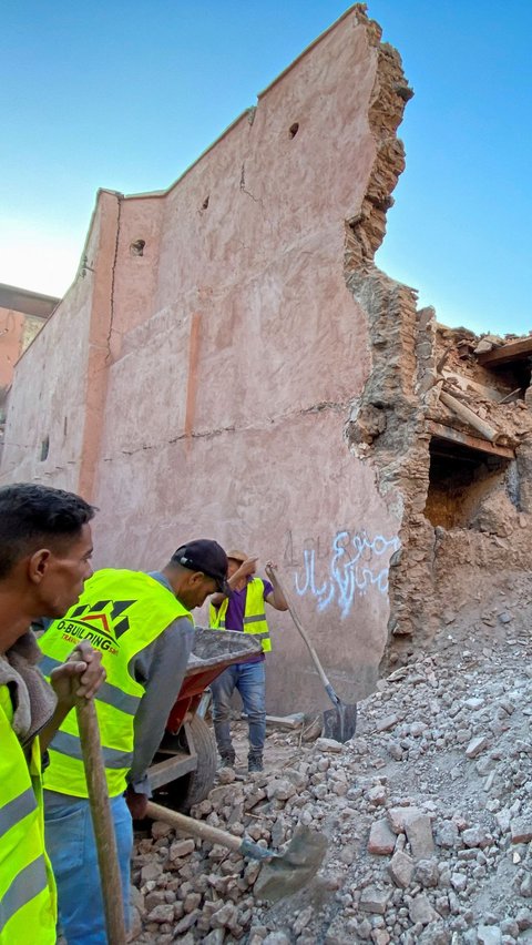 Di Desa Amizmiz dekat pusat gempa, tim penyelamat menyingkirkan reruntuhan dengan tangan kosong. Reruntuhan batu bata menghalangi jalanan sempit.