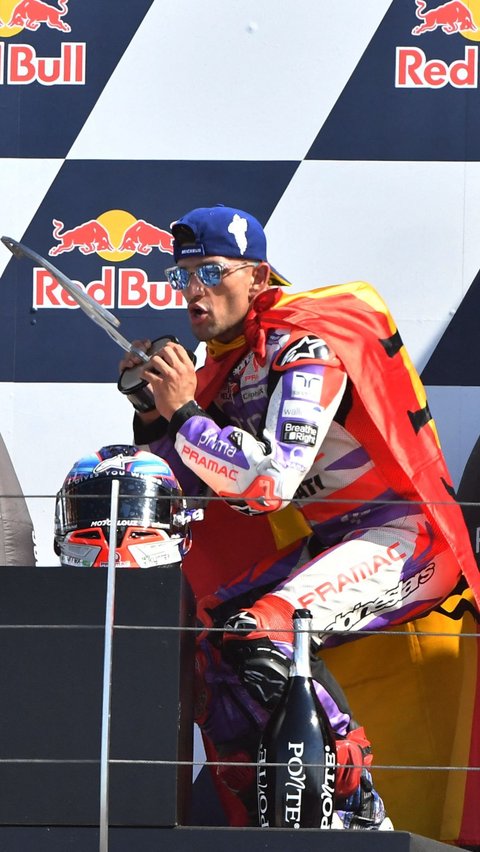 Gaya selebrasi Jorge Martin saat merayakan kemenangannya di atas podium.
