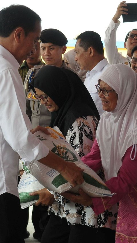 FOTO: Usai Pantau Persediaan Beras di Gudang Bulog, Jokowi Mulai Bagi-Bagi Sekarung Beras untuk Warga