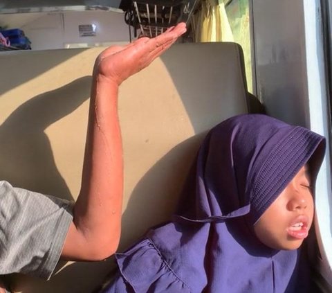 Dalam video viral itu, terlihat sang anak sedang tertidur pulas sambil menyandarkan kepalanya di dekat jendela kereta. Sang ayah pun tidak ingin anaknya terbangun karena kejatuhan air AC yang bocor.