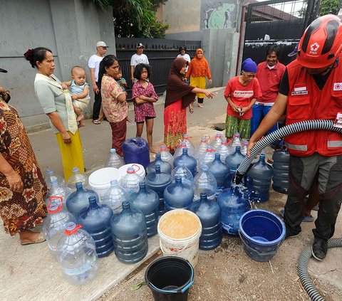 Petugas Palang Merah Indonesia (PMI) mengisi galon milik warga saat mendistribusikan bantuan air bersih di RW 10, Cipayung, Kota Depok, Kamis (14/9/2023).<br>