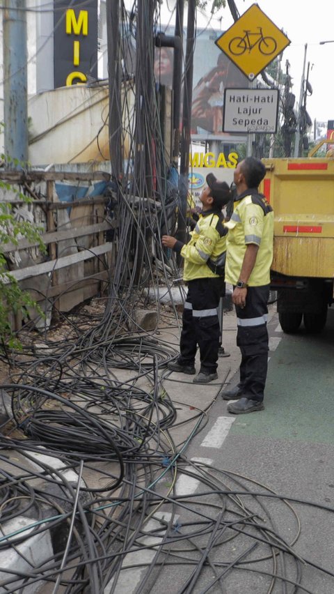 Petugas Dinas Bina Marga DKI Jakarta saat melakukan penataan kabel utilitas di kawasan Kapten Tendean.