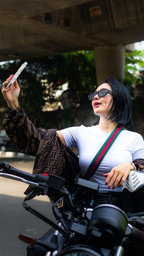 Portrait of Wika Salim riding a motorbike with friends, her outfit is captivating!