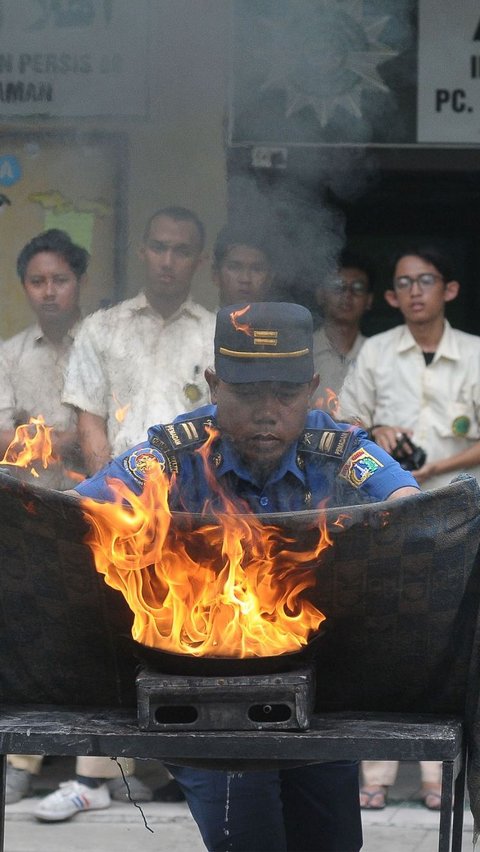 Pemadam Kebakaran DKI Jakarta memperlihatkan salah satu cara memadamkan api menggunakan kain basah saat pelatihan.