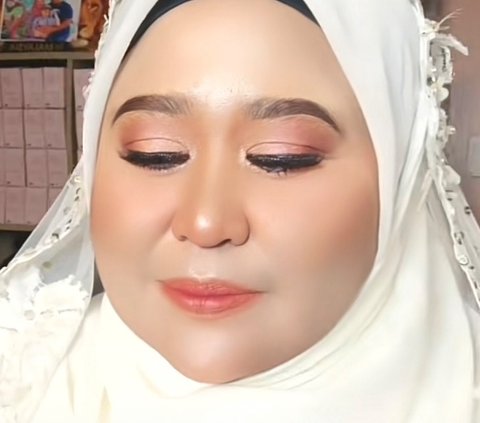 Ini potret setelah dimakeup. Tampak MUA membuat alis dengan bentuk rapi. MUA ini berhasil membuat wajah emak-emak ini terlihat lebih kencang dengan foundation dan concealer.