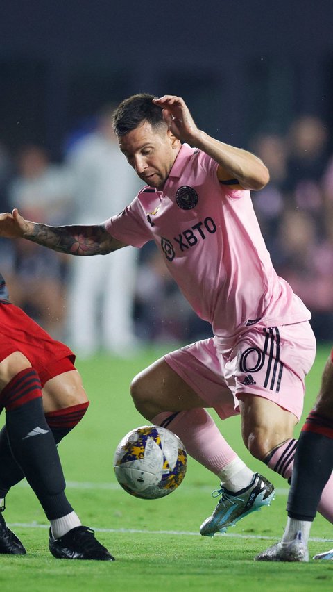 Aksi Lionel Messi saat mendapat tekanan dari dua pemain Toronto FC di DRV PNK Stadium di Fort Lauderdale, Florida (20/9/2023).<br>