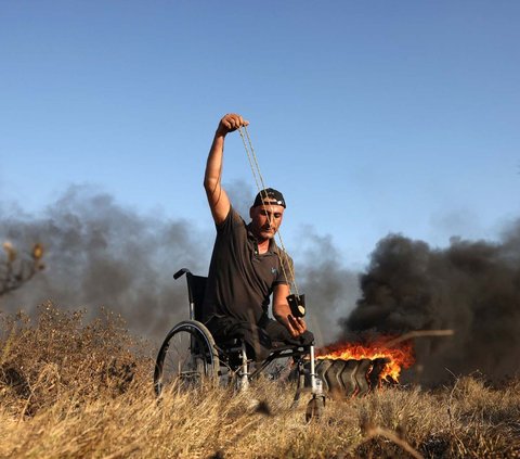 FOTO: Protes di Gaza Memanas, Pria Palestina Berkursi Roda Ini Tak Gentar Hadapi Tentara Israel