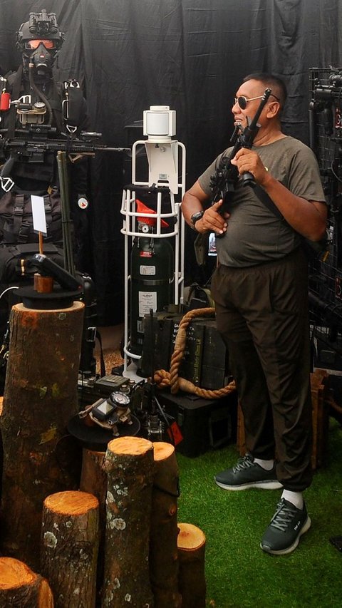 Warga berpose memagang peralatan militer saat Pameran Alat Utama Sistem Senjata (Alutsista) TNI di Lapangan Monas, Jakarta, Munggu (24/09/2023).