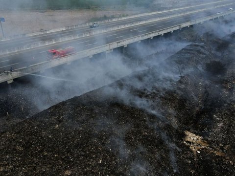 FOTO: Bahaya! Asap Kebakaran Tempat Pembuangan Sampah Ilegal di Desa Sumber Jaya Ganggu Jarak Pandang Pengguna Tol Cibitung-Cilincing