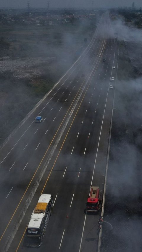 Dari pantauan udara terlihat sejumlah kendaraan memperlambat lajunya akibat kabut asap dari kebakaran TPS ilegal di samping Tol Cibitung-Cilincing.