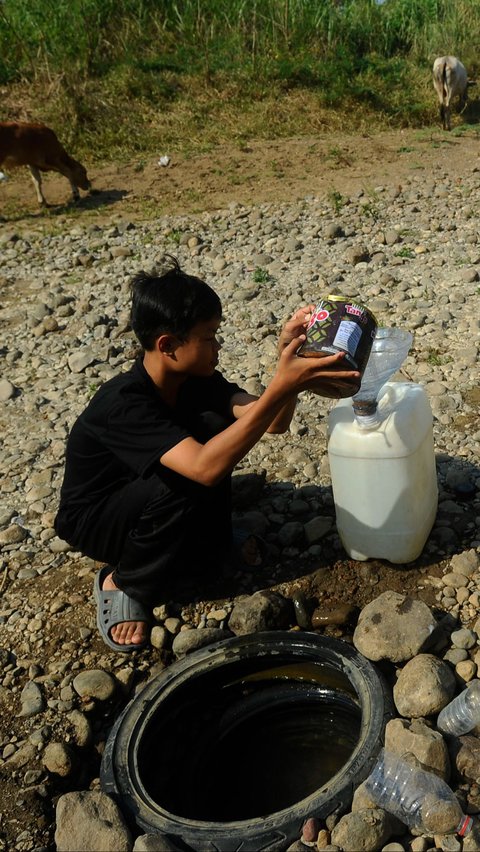 Warga mengambil air dari galian sumur di tengah Sungai Cihoe, Kamis (28/9/2023).