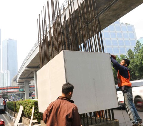 Aktivitas pekerja saat memasang banner KTT ASEAN pada tiang monorel di kawasan Jalan Rasuna Said, Jakarta, Minggu (3/9/2023).