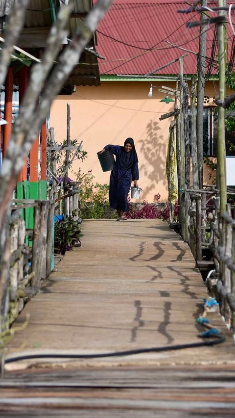 Seorang perempuan berjalan di Desa Monggak di Pulau Rempang.