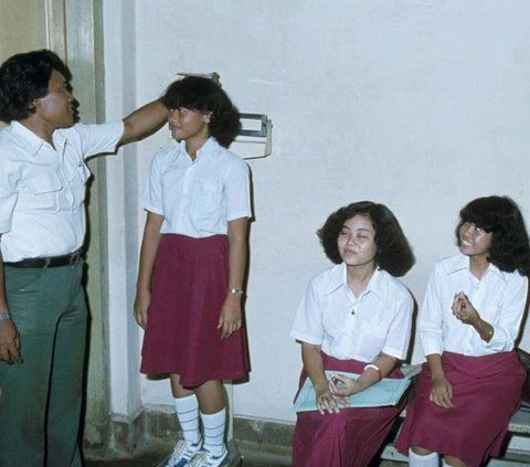 Old Photo of Elementary School Students in 1980, Red-White Uniforms but the Headmaster's Face