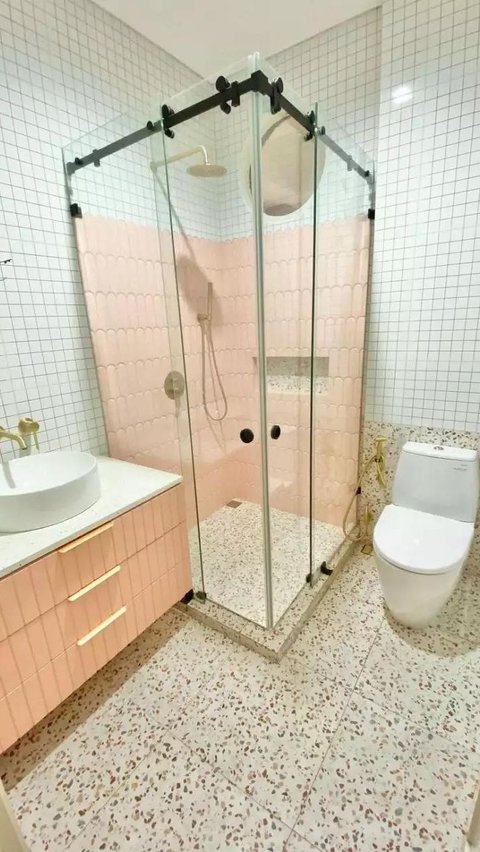 Kamar mandinya terlihat modern dan sangat mewah, dengan peralatan yang lengkap. Tampak area shower disendirikan dalam ruang kaca.
