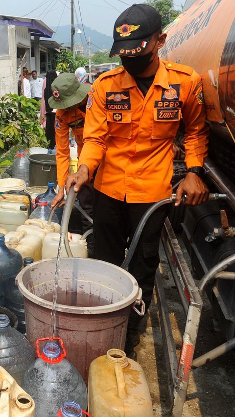Sejumah petugas BPBD Kab Bogor mengisikan air bersih ke dalam ember milik warga terdampak kekeringan di Desa Tajur, Citeureup, Bogor, Kamis (07/09/20223).