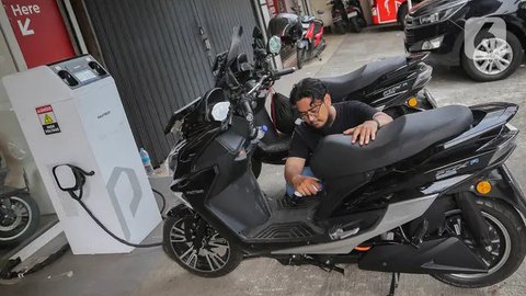 Pengunjung melakukan pengisian energi pada sepeda motor listrik di Jakarta, Jumat (12/1/2024). Pemerintah melalui Kementerian Perindustrian memangkas kuota subsidi sepeda motor listrik pada tahun ini, dari rencana awal 600.000 unit menjadi 50.000 unit.