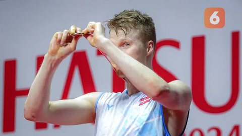 Pebulutangkis tunggal putra Denmark, Anders Antonsen mengangkat medali emasnya setelah memenangkan Indonesia Masters 2024.<br>(Foto Bola.com / Bagaskara Lazuardi)<br>