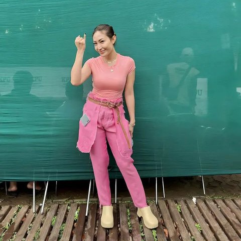 Ayu Dewi tampil serba pink saat coblosan di TPS dekat rumahnya.