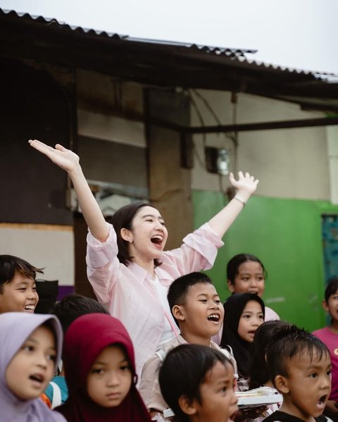 Dalam balutan blouse merah muda dan rambut pendek, mantan personel Blink itu tampil kasual sambil tersenyum bahagia.<br>