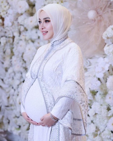 Syahrini appeared in an all-white outfit while showing off her stomach.