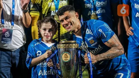 Striker Persib Bandung, Ciro Alves dan putrinya, Bella berpose bersama trofi saat perayaan gelar juara Championship Series BRI Liga 1 2023/2024 di Stadion Gelora Bangkalan, Madura, Jumat (31/5/2024). Persib Bandung sukses membungkam Madura United dengan skor agregat 6-1 di laga final. Foto: Bola.com/Bagaskara Lazuardi