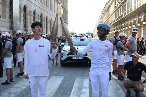 Seperti pembawa obor lainnya, Jin juga mengenakan jersey serba putih khas Olimpiade Paris.