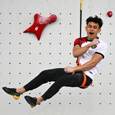 Atlet panjat tebing Indonesia, Veddriq Leonardo merayakan kemenangan pada babak final cabang olahraga pajat tebing nomor speed Olimpiade Paris 2024 di Le Bourget Sport Climbing Venue, Paris, Prancis, Kamis (08/08/2024). (AFP/Fabrice Coffriri)