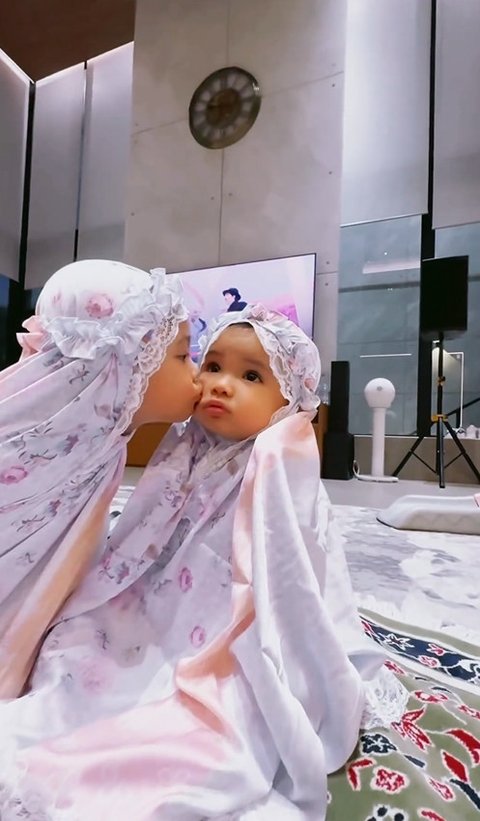 Ameena dan Azura tampak menggemaskan dalam mukena mungil yang mereka pakai. 