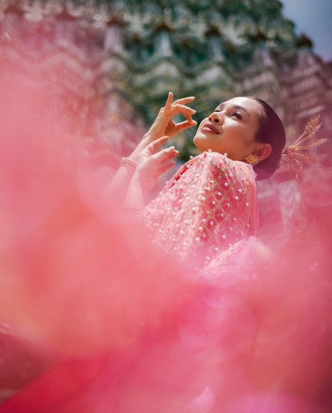 Andien tampil anggun dalam balutan Chut Thai di Wat Arun, kuil tercantik di Thailand, berpose dengan sempurna di depan kamera suami tercintanya.<br><br>