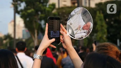 FOTO: Tak Bisa Masuk GBK, Umat Katolik Tetap Khidmat Ikuti Misa Suci Paus Fransiskus Meski Lewat Layar Lebar