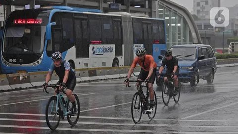 Warga menggunakan payung saat hujan mengguyur kawasan Monas, Jakarta Pusat, Kamis (5/1/2023). Warga diharapkan waspada serta mempersiapkan diri dengan perubahan cuaca yang akan terjadi selama
