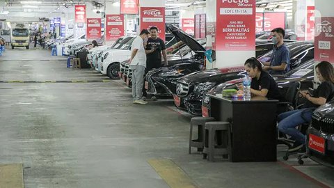 Pekerja membersihkan mobil yang dijual di Showroom Belanja Mobil, Jakarta, Senin (6/2/2023). Guna menghadirkan kebutuhan mobil bekas untuk masyarakat Indonesia saat ini, sejumlah showroom mob