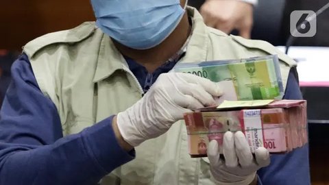 Petugas menunjukkan barang bukti berupa pecahan uang Dolar Singapura hasil OTT hakim Pengadilan Negeri Jakarta Selatan saat konferensi pers di gedung KPK, Jakarta, Rabu (28/11). Dalam kasus t