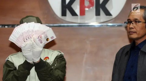 Petugas menunjukkan barang bukti berupa pecahan uang Dolar Singapura hasil OTT hakim Pengadilan Negeri Jakarta Selatan saat konferensi pers di gedung KPK, Jakarta, Rabu (28/11). Dalam kasus t