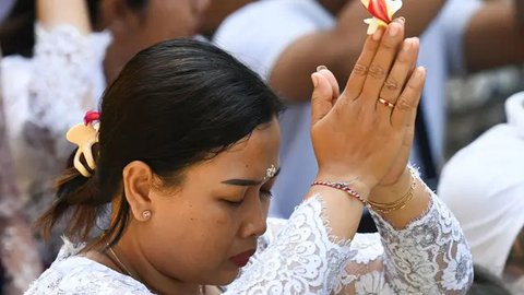 Seorang wanita Bali berdoa di sebuah pura untuk merayakan Galungan di Denpasar, Bali, pada tanggal 25 September 2024. (SONNY TUMBELAKA/AFP)