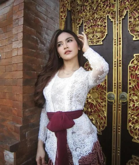 Manisnya penampilan Mahalini Raharja pakai kebaya Bali berwarna putih polos, dipadukannya mengenakan kain wastra bernuansa ungu wine dan selendangnya yang senada, yang diikatkannya di pinggan