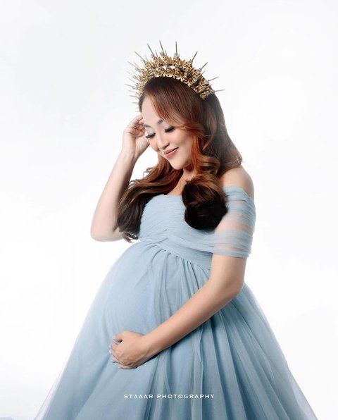 Mengenakan gaun berwarna baby blue yang melambangkan ketenangan, Mpok Alpha tampil cantik alami dengan makeup simpel, ditambah headpiece yang semakin menambah pesonanya.<br>