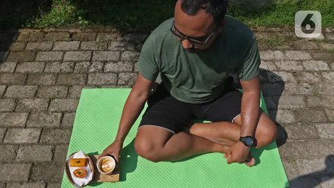 Pelanggan berjemur di halaman kedai kopi Nyambi Ngopi, Depok, Jawa Barat, Selasa (3/8/2021). Kedai kopi tersebut menjadikan halamannya untuk program Ngopi Sambil Berjemur pada pukul 09.00 - 1