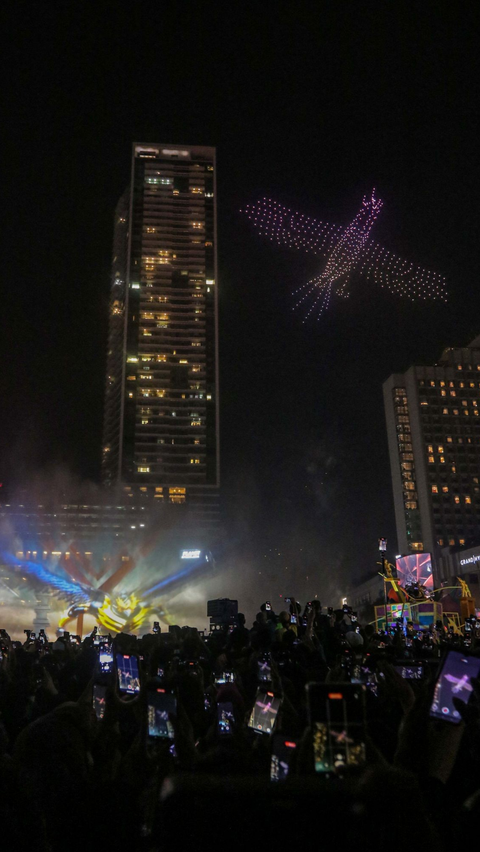 Atraksi formasi drone dan 'video mapping' mewarnai malam pergantian tahun di kawasan Bundaran Hotel indonesia (HI), Jakarta, Senin (1/1/2024).