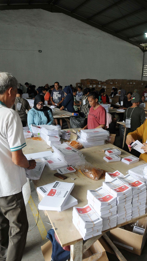 Aktivitas para pekerja saat melakukan pelipatan pada surat suara yang layak untuk dilipat setelah melalui tahapan sortir.<br>(merdeka.com / Imam Buhori)<br>