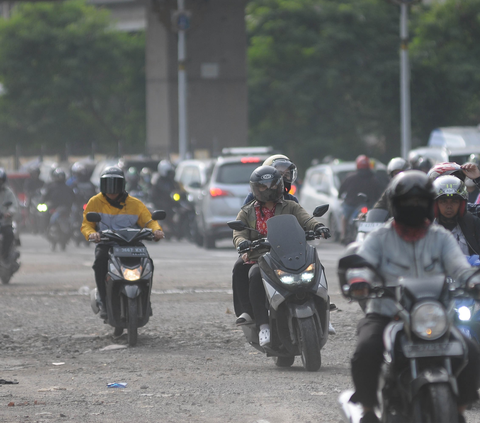 Pengendara bermotor saling berebut jalan saat melintasi Jalan Raya Kalimalang yang padat merayap di Jakarta, Kamis (11/1/2023).