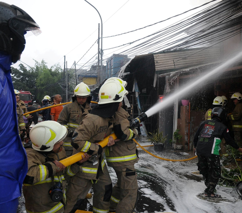 Petugas pemadam kebakaran berusaha memadamkan api yang membakar rumah di Kawasan Manggarai, Jakarta, Kamis (11/1/2024).