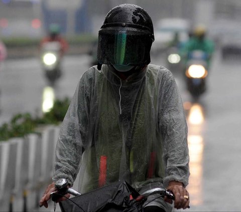 Warga menggunakan payung saat terjadi hujan deras disertai angin di kawasan MH THamrin, Jakarta, Kamis (11/1/2024)
