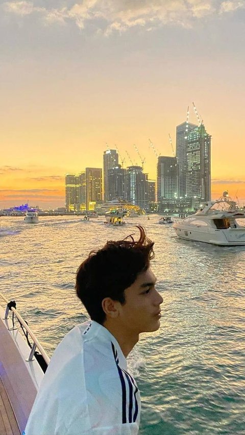 Dari puncak yacht, Eddy menikmati keindahan kota Dubai pada golden hour, menciptakan momen yang tak terlupakan.