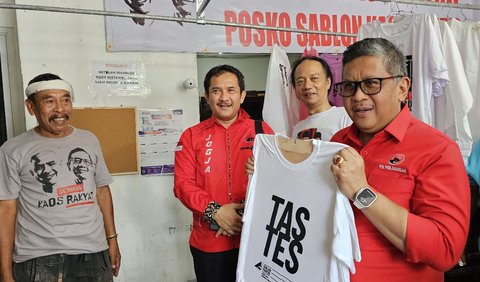 Kaos putih itu disablon Hasto dengan tulisan Tas Tes yang menjadi jargon kampanye Ganjar-Mahfud.<br>