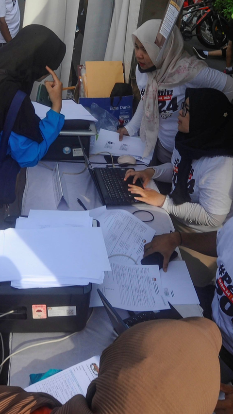 Antrean warga saat mengurus surat pindah TPS (Tempat Pemungutan Suara) Pemilu pada stand yang digelar KPU di Bundaran HI.<br>(Foto merdeka.com / Arie Basuki)<br>