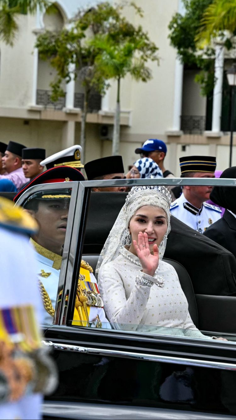 Pangeran Abdul Mateen bersama Yang Mulia Anisha Rosnah melambaikan tangan kepada masyarakat.<br>( Foto MOHD RASFAN / AFP )<br>