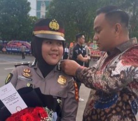 Pria ini memasangkan pangkat baru sang istri dengan penuh kasih sayang. Diketahui sang istri mendapatkan kenaikan pangkat menjadi Iptu. <br>