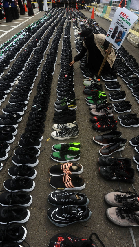 Dalam aksi simbolis ini mereka menggelar lebih dari 1.000 pasang sepatu anak-anak di depan Kedubes AS, Jakarta, Senin (15/01/2024).<br>( Foto merdeka.com / Arie Basuki )<br>